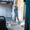 Laborer polishing sand and cement screed floor.