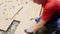 Laborer in uniform taps with hammer on tiles at construction