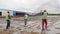 Laborers carry large metal grid to put on ground with foil