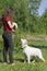 Labrador dog standing at leg of owner, waiting for command. Girl trains her pet outdoor. Obedience, dog training, friendship,