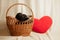 Labrador puppies in a wicker basket and next to a pillow in the shape of a red heart in the studio, f dogs and love