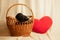 Labrador puppies in a wicker basket and next to a pillow in the shape of a red heart in the studio, f dogs and love