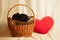 Labrador puppies in a wicker basket and next to a pillow in the shape of a red heart in the studio, f dogs and love
