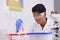 Daily labwork. A beautiful young scientist dropping a substance into test tubes in her lab.