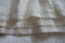 Lace ribbons stitched to frills on hem of skirt