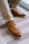 Laced brown brogues on the groom's legs. Close-up