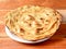Lachha Paratha, a layered flat bread using wheat flour, popular dish in north India. isolated over a rustic wooden background,
