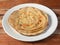 Lachha Paratha, a layered flat bread using wheat flour, popular dish in north India. isolated over a rustic wooden background,