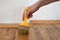 Lacquering wood floors. Worker uses a brush to coating floors