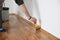 Lacquering wood floors. Worker uses a brush to coating floors