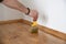 Lacquering wood floors. Worker uses a brush to coating floors