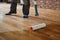 Lacquering wood floors. Worker uses a roller to coating floors