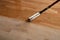 Lacquering wood floors. Worker uses a roller to coating floors