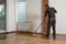 Lacquering wood floors. Worker uses a roller to coating floors