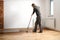 Lacquering wood floors. Worker uses a roller to coating floors