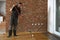 Lacquering wood floors. Worker uses a roller to coating floors