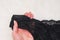 Lacy black panties in female hand. Close up. Fashionable concept of lingerie