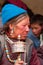 Ladakhi women with hand prayer wheels in traditional clothes and jewelry prays with eyes closed on buddhist festival in Lamayuru