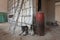 Ladder, dusty and dirty rubber boots of workers and big gas boiler in apartment during during on the remodeling