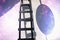 Ladder leading to a portion of starry sky. Abstract composition with black ladder and ovoid shadow with night sky and