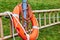 Ladder and lifebuoy at the edge of a lake in a park