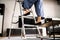 Ladder Safety. Woman Climbing Step Ladder