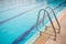 Ladder stainless handrails for descent into swimming pool. Swimming pool with handrail.