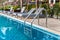 Ladder stainless handrails for descent into swimming pool. Swimming pool with handrail . Ladder of a swimming pool. Horizontal sh