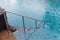 Ladder stainless handrails for descent into swimming pool. Swimming pool with handrail . Ladder of a swimming pool. Horizontal sho