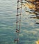 The ladder of success is never crowded at the top. Rope ladder with wooden steps. Rope over water surface. Rescue or