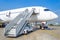 Ladder to the entrance of the aircraft in the parking lot at the airport, view the nose of the aircraft.