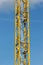 Ladder in tower of yellow crane in blue sky