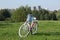 Ladies` bike in red and white. Stands in the park on the lawn. Multi-storey buildings under construction are visible on the