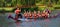 Ladies dragon boat team in orange racing on the river Ouse.
