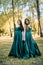 Ladies in elegant green dresses walking in autumn park. Brunette girl Dreamy young girls laughing on the outdoors