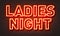 Ladies night neon sign on brick wall background.