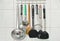 Ladle flipper and colander with other kitchenware mobile on stainless hanger in kitchen