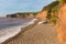 Ladram Bay shingle beach Devon England UK with boats red sandstone rock Jurassic coast