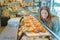 Lady in bakery looking longingly into counter