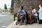 Lady, Blind Man beside disabled Beggar in wheelchair at Church yard Gate Portal