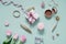 Lady bloggers desktop with pink flowers, tulips, cosmetics and a gift box with a bow. Flat lay