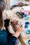 Lady ceramic artist working in her studio interior, woman`s hands painting objects