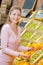 Lady choosing oranges in grocers