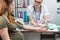 A lady doctor checks the result after testing a pregnant patient with a blood pressure monitor. A married couple in a