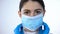 Lady doctor in surgical gloves puts on mask, disease prevention, healthcare