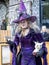 Lady dressed up as witch in purple garment on street
