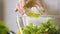 Lady dressing fresh summer salad with olive oil, diet food, slow motion