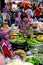 Lady examines vegetables as fresh food market bazaar in Hatyai Thailand