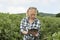 Lady in Farm Stares Seriously on her Mobile Device`s Screen