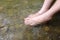 Lady feet steep into the stream